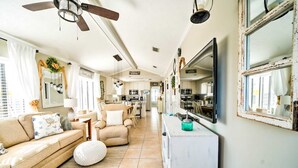 A spacious living room with a sofa, armchairs, a coffee table, and a TV. - 264 Seahorse Lane - 3 Bedroom with Golf Cart Included! (Panama City Beach)