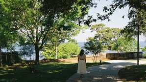 A pathway leading to a body of water with trees on either side. - The Fairhope Bay Room (Fairhope)