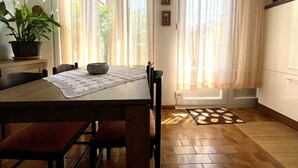 A dining area with a wooden table, chairs, and a potted plant. - Apartment Maria close to the beach and city center (Umag)