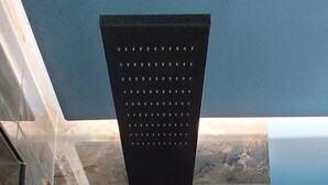 Ein modernes Badezimmer mit Duschbereich, Marmorwänden und einer Deckenleuchte.