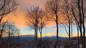 A snowy landscape with bare trees and mountains in the background. - Mountaintop at Yonahlossee Saddle (Boone)