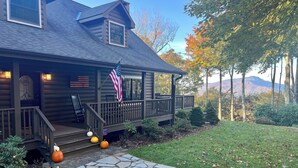 A log cabin with a porch, stone pathway, and autumn decorations. - Mountaintop at Yonahlossee Saddle (Boone)