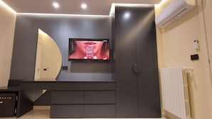 A modern bathroom with a built-in vanity, a mirror, a television mounted on the wall, and a radiator. - Romantic Junior Suite with Canal View a stone's throw from Corso Vittorio Emanuele (Avellino)