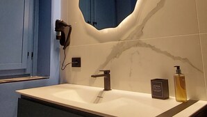 A modern bathroom with a large mirror, a built-in sink, and a hairdryer on the wall. - Romantic Junior Suite with Canal View a stone's throw from Corso Vittorio Emanuele (Avellino)