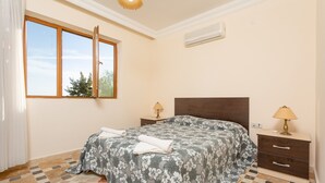 A bedroom with a bed, two bedside tables, a nightstand, a window, and a ceiling light. - 2 Bedroom sea view Kalkan in the center - Cactus (Antalya)