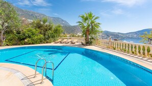A clear blue swimming pool with a view of mountains and a body of water in the background. - 2 Bedroom sea view Kalkan in the center - Cactus (Antalya)