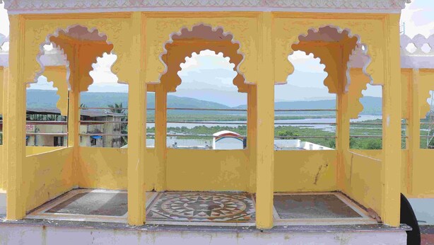 A yellow structure with arched openings and a patterned floor. - JK Sea Palace (Shrivardhan)