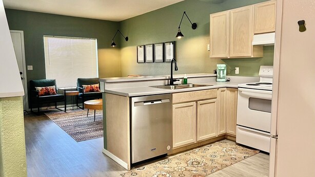 A modern kitchen with a central island, stainless steel appliances, and light wood cabinetry. - 2BR Historic Downtown Townhouse. Near Mt. Rainier, Waterfalls & Wildlife (Eatonville)