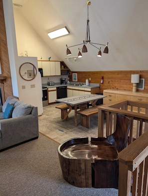 Una cocina moderna con armarios de madera, una mesa de comedor y un horno empotrado.
