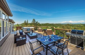 Eine Terrasse mit Gartenmöbeln, einem Grill und schöner Aussicht.