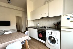 A compact kitchen with a built-in washing machine, a dining area with a table and chairs, and a modern design. - A39 - Ancona, comfortable three-room apartment in the historic center (Ancona)