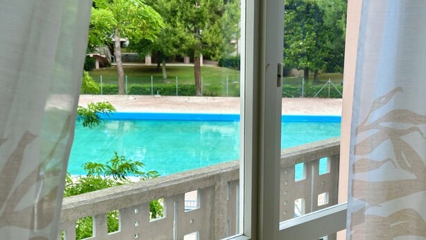 A view of a swimming pool with a concrete deck and trees in the background. - M398 - Marcelli, three-room apartment with terrace in residence with pool (Marcelli)