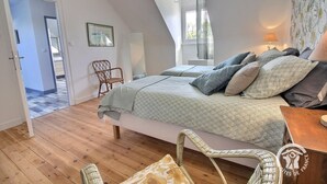 Un dormitorio con cama, una silla, una lámpara y una ventana.