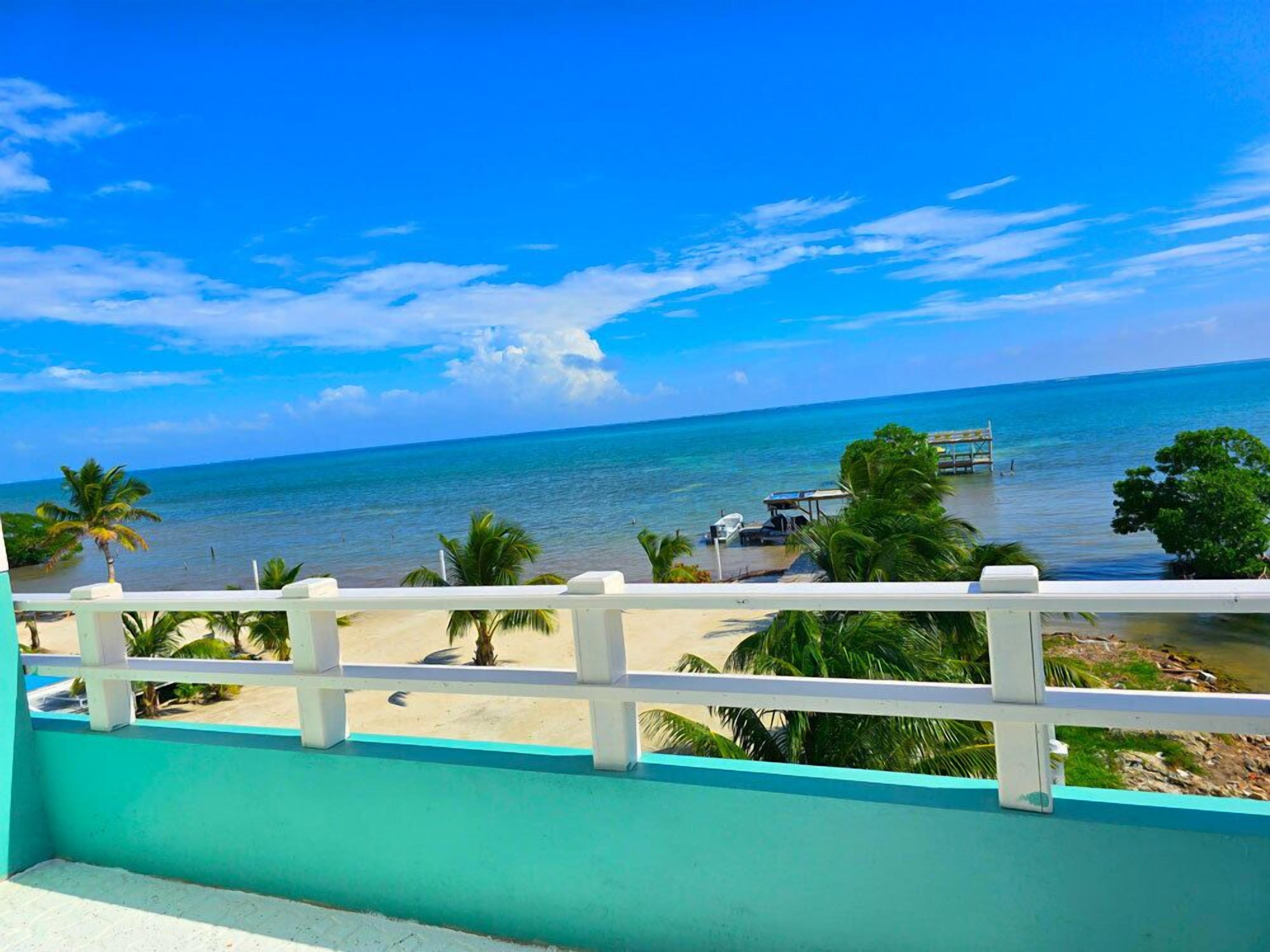 A view from a balcony overlooking a beach with a clear sky.