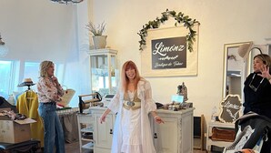 Ein stilvolles Interieur mit einer Chandelieber, einem Schild mit der Aufschrift "Limónz Boutique de Tubos" und einem gemusterten Sessel.