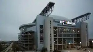 A modern stadium with a prominent 'NRG Stadium' sign.