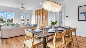 A modern dining area with a wooden table set for four, surrounded by wooden chairs.