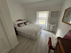 2 habitaciones, escritorio y tabla de planchar con plancha