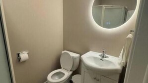 Ein kleines Badezimmer mit Toilette, Waschbecken und Spiegel.