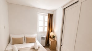 Une chambre à coucher avec un lit, une table de chevet, une lampe et une armoire.