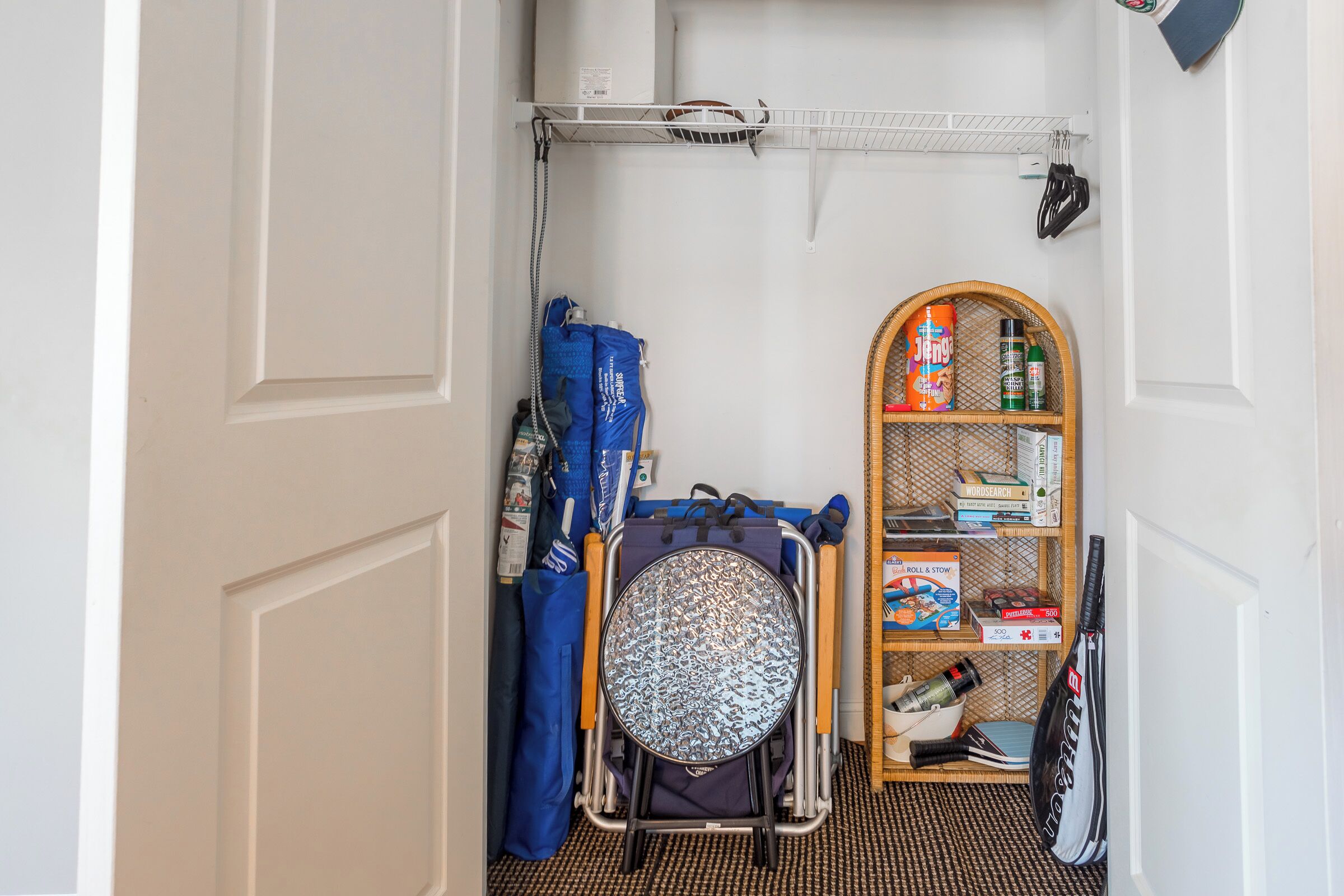 A narrow hallway with a wheelchair, a shelf with cleaning supplies, and a door.