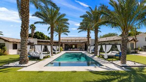 A poolside area with a rectangular pool, palm trees, and outdoor seating with white curtains. - 3.5 Acre compound- 2 pools, tennis, pickleball, basketball, sauna & steam + more (Bermuda Dunes)
