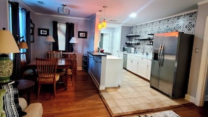A compact living space with a dining area, kitchen, and a small seating area with a sofa. - Cozy home in quiet neighborhood  (Memphis)
