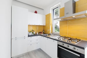 Une cuisine moderne avec des meubles blancs, une cuisinière à gaz et une fenêtre offrant une belle vue.