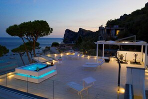 A rooftop pool area with lounge chairs and a modern pool design.