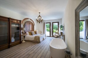 A bedroom with a large bed, a bathtub, and a wooden wardrobe. - MyExclusiveItaly - Chianti's Villa | Vineyard, infinity pool, view (Greve in Chianti)