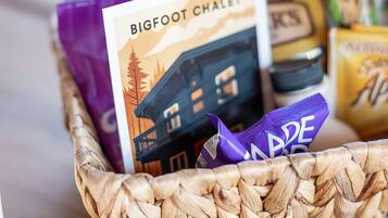 A basket containing a variety of food items including a bag of Buttermilk, a package of Bigfoot Chalet, and other snacks.