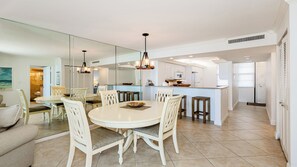 A modern kitchen with white cabinetry, a central island, and pendant lighting.