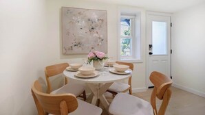 A dining area with a round table, six chairs, and a vase with flowers. - Cozy& Chic 1BR 1BA Lower Unit Near Lake Union (Seattle)