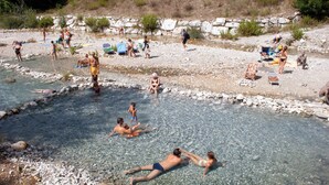 Zona para nadar en un entorno natural, con aguas transparentes, rodeada de rocas y vegetación.