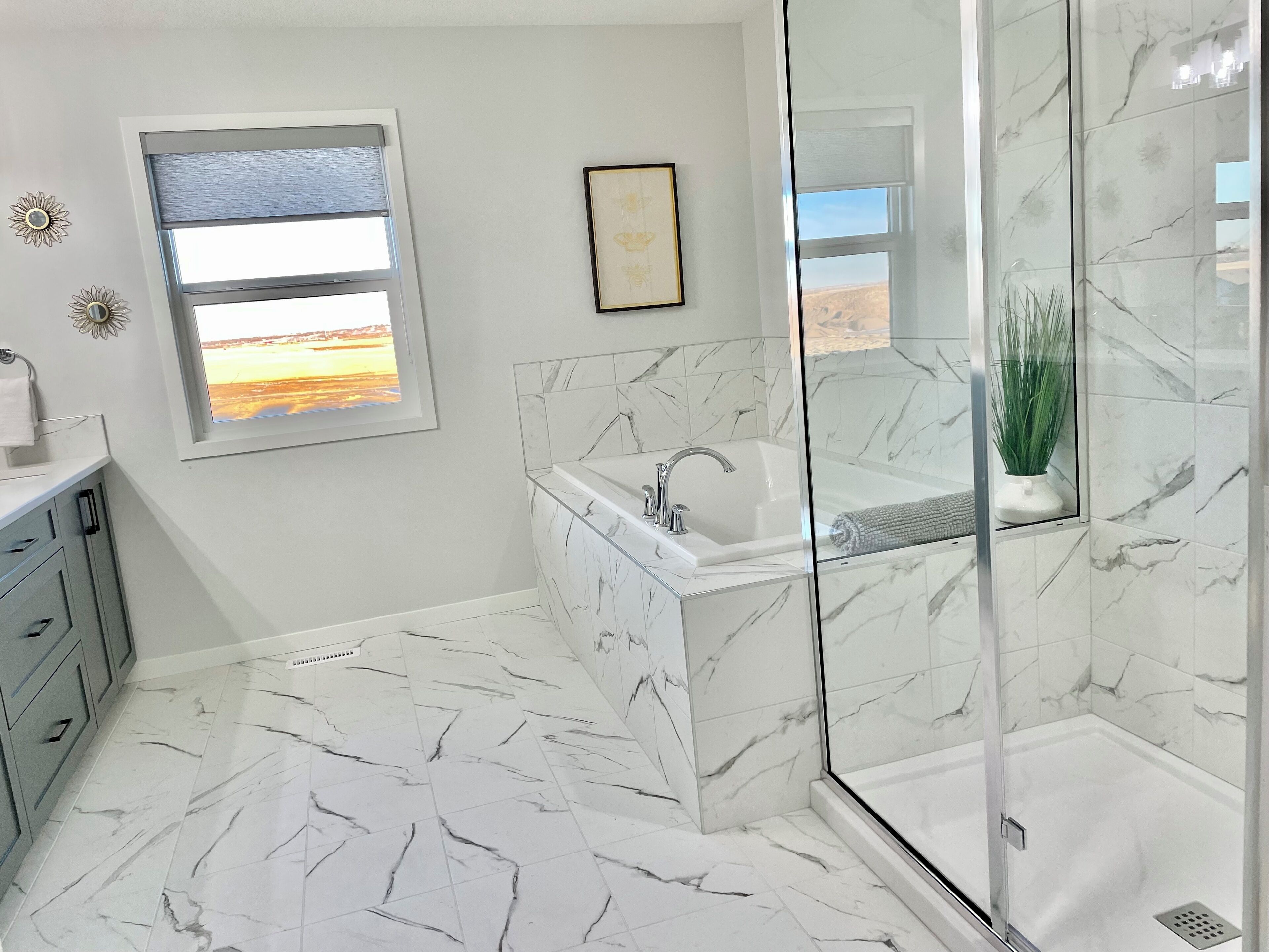 Une salle de bain moderne dotée d’une douche à parois de verre, d’une baignoire et d’une fenêtre donnant sur une plage.