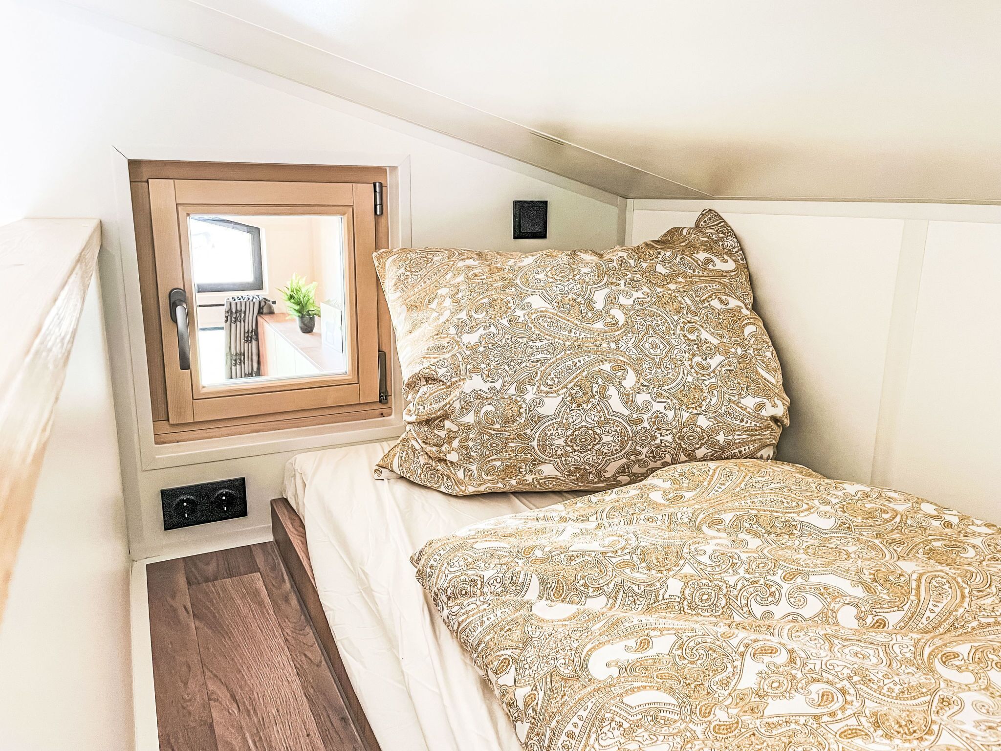 A bedroom with a bed, a window, and a small potted plant.