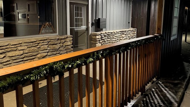 A building with a stone facade, wooden railings, and a door with glass panels. - Modern 2 Bed Suite on Bourbon Trail (Loretto)