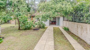 A garden with a pathway leading to a small structure with a tiled roof.