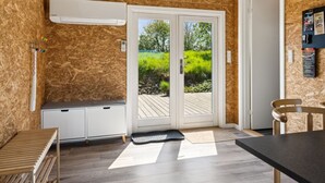 A modern kitchen with a built-in stove, a bench, and a view of the outdoors through a glass door. - "Sölvy" - 300m from the sea by Interhome (Børkop)