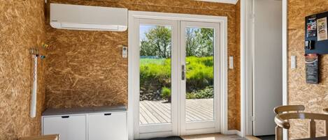 Una cuina moderna amb fogó integrat, una banca i vistes a l'exterior a través d'una porta de vidre.