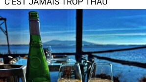 A table with a bottle of wine, two glasses of wine, and a box of oysters. - Appartement 40m2,vue Exceptionnelle. 1 Chambre Indépendante. Climatisation (Sète)