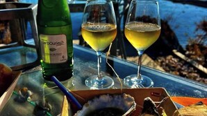 A table with a bottle of wine, two glasses of wine, and a box of oysters. - Appartement 40m2,vue Exceptionnelle. 1 Chambre Indépendante. Climatisation (Sète)