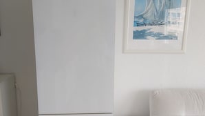 A white refrigerator in a room with a white sofa and a framed picture on the wall. - Appartement 40m2,vue Exceptionnelle. 1 Chambre Indépendante. Climatisation (Sète)