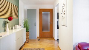 Eine moderne Küche mit Holztür, einem weißen Schrank und einem Blumentopf.