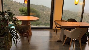 Une pièce moderne avec une grande fenêtre, une table ronde et deux chaises.