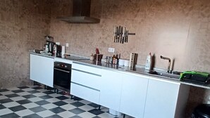 Une cuisine avec un carrelage à motifs, des placards blancs et une hotte de cuisine en acier inoxydable.