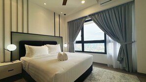 Een moderne hotelkamer met een groot bed, een plafondventilator, een airconditioning en uitzicht op de stad.