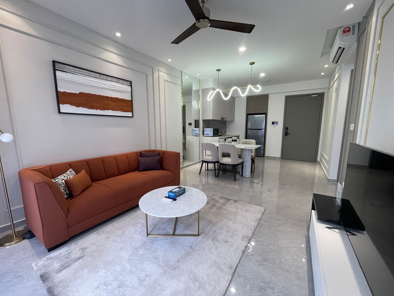A modern living room with a sofa, coffee table, and dining area.