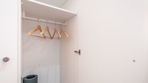 A closet with wooden hangers and a black cylindrical object. - Steil Alva Studios Smit by Interhome (Lenzerheide)