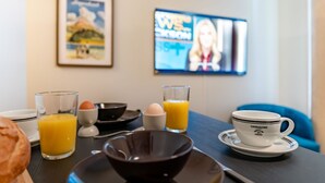 A breakfast setup with a coffee cup, orange juice, and a bowl on a table. - Steil Alva Studios Smit by Interhome (Lenzerheide)